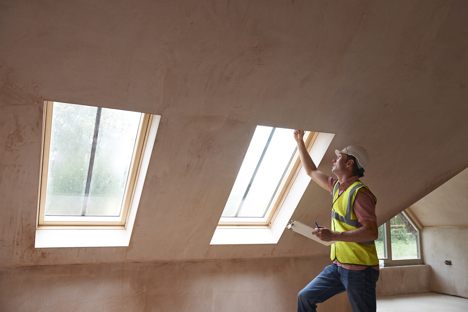 Inspector checking window frames in a newly finished property during a snagging walkthrough